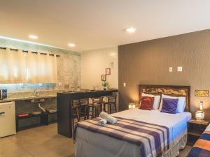 um quarto com uma cama e uma cozinha com um lavatório em Pousada Rosa Karioka na Praia do Rosa