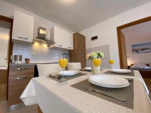 a kitchen with a table with glasses of orange juice at Apartment in Silo/Insel Krk 13424 in Šilo