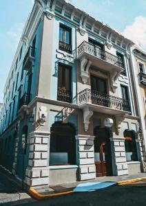 niebiesko-biały budynek z balkonami przy ulicy w obiekcie EL Colonial Adults Only w mieście San Juan