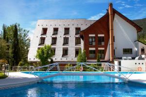 a hotel with a swimming pool in front of a building at Silken Ordesa in Torla