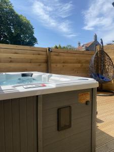 a hot tub sitting on a deck next to a fence at St Hildas Complex in Hinderwell