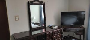 een televisie die op een dressoir voor een spiegel staat bij San Borja Habitación amoblada TV 42 OK in Lima