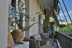 a balcony with chairs and plants on a building at Pepromeno LUXURY APARTMENT IN THE CITY CENTER in Kalamata