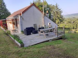 a house with a wooden deck in the yard at Gite Le Savart in Chartèves