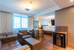 een hotelkamer met een bed en een woonkamer bij Blue Tree Premium Florianópolis in Florianópolis