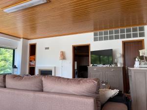 a living room with a couch and a wooden ceiling at Casa do Arco in Abiul