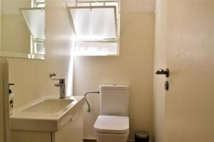 La salle de bains est pourvue de toilettes blanches et d'un lavabo. dans l'établissement The Heart Of Athens - Perfect Retreat For 2 Guests, à Athènes