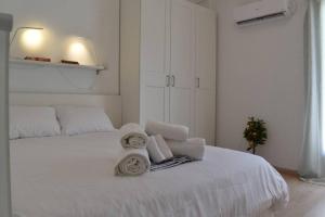 - une chambre blanche avec un lit blanc et des serviettes dans l'établissement The Heart Of Athens - Perfect Retreat For 2 Guests, à Athènes