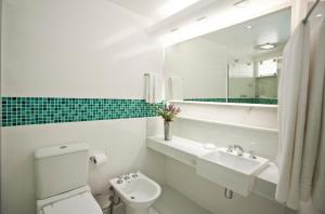 uma casa de banho com um WC, um lavatório e um espelho. em Auberge de la Langouste em Búzios