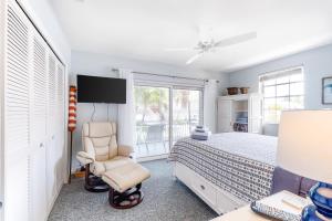 a bedroom with a bed and a chair and a window at Sun-kissed Bliss in Islamorada