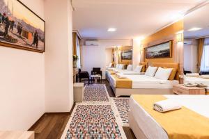 a hotel room with a bed, desk and a painting on the wall at Kadirga Antik Hotel in Istanbul