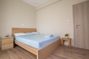 een slaapkamer met een bed met een houten hoofdeinde bij Cosy Apartment With Terrace Near Metro Station in Athene