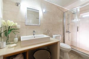 een badkamer met een wastafel, een toilet en een douche bij Casa al mare in Archangelos