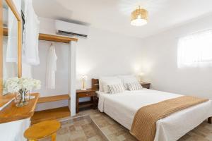 een witte slaapkamer met een bed en een tafel bij Casa al mare in Archangelos