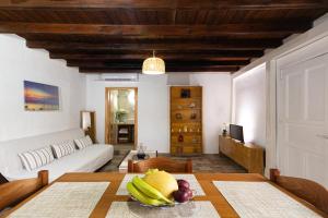 een woonkamer met een tafel met een fruitschaal bij Casa al mare in Archangelos