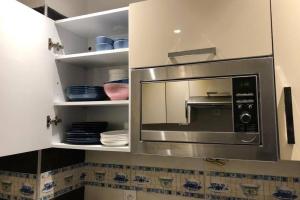a stainless steel microwave in a white kitchen at Cosy loft Saphir Cabo Negro in Cabo Negro