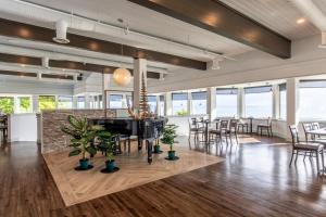 a dining room with tables and chairs and windows at Bayside Resort, Ascend Hotel Collection in Parksville