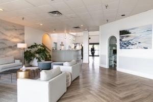 a lobby with white furniture and a painting on the wall at Bayside Resort, an Ascend Collection Resort in Parksville