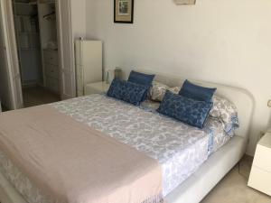 a bedroom with a large bed with blue pillows at Dominion Beach House in Estepona