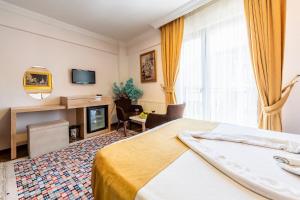 a hotel room with a bed and a tv at Kadirga Antik Hotel in Istanbul