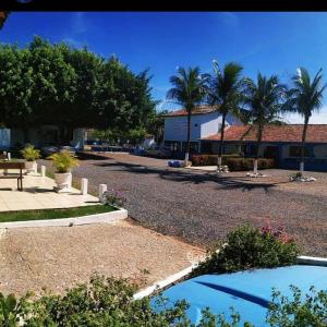 a park with palm trees and a building at Hotel Lago Azul in Bonito