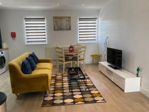 a living room with a couch and a tv and a table at Apartment No 8 - Stay in style in the heart of the Cathedral City. in Truro