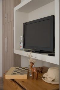 een woonkamer met een tv en een houten tafel met een tafel sidx sidx sidx bij Cosy Apartment With Terrace Near Metro Station in Athene