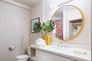 a bathroom with a sink and a mirror at White Sands Hotel in Honolulu