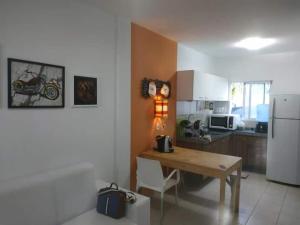 Maxaranguape的住宿－PARAÍSO DE MARACAJAÚ - BEIRA MAR，厨房配有木桌和白色冰箱。
