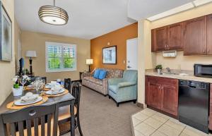 a kitchen and living room with a table and a couch at Near Disney - 1 Bed King Suite - Pool and Hot Tub in Orlando