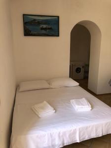a large white bed with two white towels on it at Il Cortiletto - Lipari CENTRO in Lipari