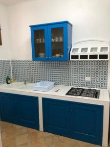 La cuisine est équipée de placards bleus et d'un four avec plaques de cuisson. dans l'établissement Il Cortiletto - Lipari CENTRO, à Lipari