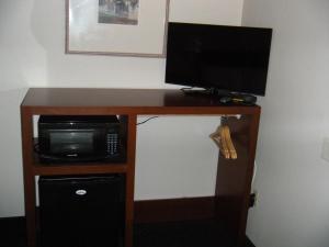 a desk with a microwave and a television on it at Western Motel in Salinas