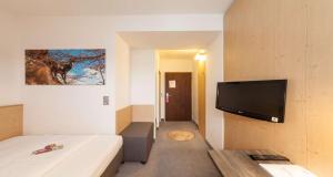 a room with a bed and a flat screen tv at Sure Hotel by Best Western Muenchen Hauptbahnhof in Munich