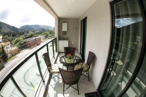 a balcony with a table and chairs on a balcony at Apartamento Decorado na Serra em Itaipava in Petrópolis