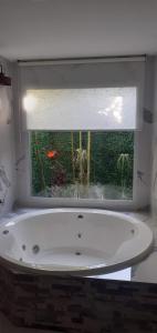 y baño con bañera y ventana. en Cabañas Tunita´s en Coronel Suárez