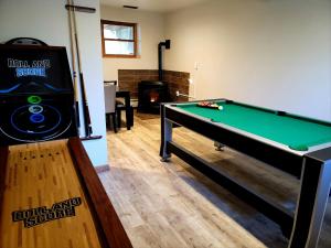 sala de estar con mesa de billar y chimenea en The Pocono's Retreat with a Gameroom, Firepit, and Lake en Bushkill