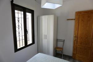 Schlafzimmer mit einem Bett, einem Fenster und einem Schrank in der Unterkunft Calle San Basilio - Patios. Aparcamiento gratis in Córdoba