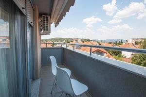 two white chairs on a balcony with a view at OASIS Apartments in Gevgelija