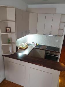 une cuisine avec des placards blancs et un comptoir dans l'établissement Belgradian 011, à Belgrade