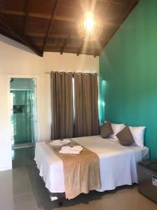 a bedroom with a large bed in a room at Foca Guest House in Búzios