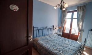 sypialnia z łóżkiem z niebieskimi ścianami i oknem w obiekcie Agriturismo Al Brich Quadriple room with breakfast w mieście Albaretto Della Torre  +16 zdjęć