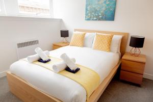 a bedroom with a bed with towels on it at Modern Merchant City Apartment by George Square in Glasgow