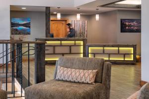 a man standing at a counter in a room with a chair at Creekside at Beaver Creek in Beaver Creek