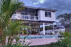een groot wit huis met een zwembad bij CASA VACACIONAL DE PLAYA in Nueva Gorgona