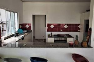 a kitchen with a sink and a counter with stools at CASA VACACIONAL DE PLAYA in Nueva Gorgona