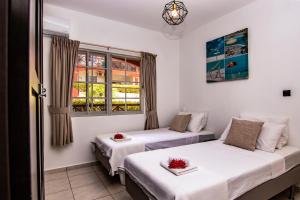 ein Zimmer mit zwei Betten und einem Fenster in der Unterkunft Chico's Seru Hulanda Resort in Willemstad + 21 Fotos