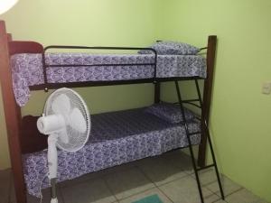 Habitación con 3 literas y ventilador. en Morpho Casa Vacacional, en Fortuna