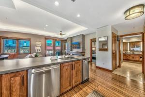 una cucina a pianta aperta con armadietti in legno ed elettrodomestici in acciaio inossidabile di Luxury 2Br Residence Steps From Heavenly Village & Gondola Condo a South Lake Tahoe