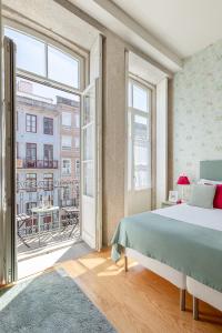 ein Schlafzimmer mit einem Bett und einem großen Fenster in der Unterkunft Inside Porto Apartments - Mouzinho in Porto